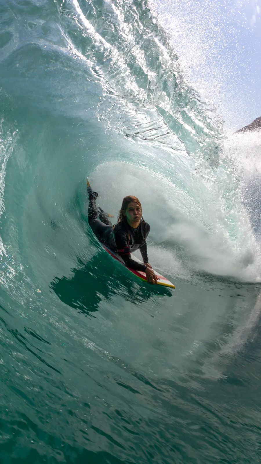 Isabela Sousa surfando dentro de um tubo.