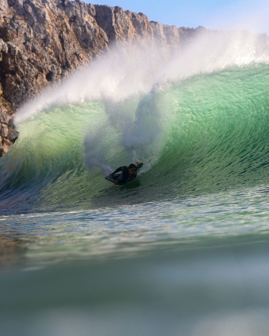 Onda tubular quebrando junto a uma parede de pedra.