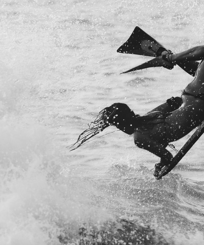 Isabela Sousa em uma manobra aérea de bodyboard, foto em preto e branco.